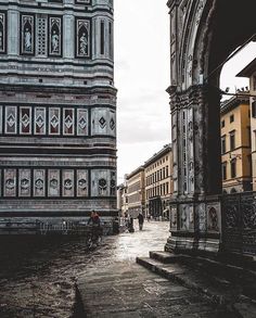 an old building with people walking down the street