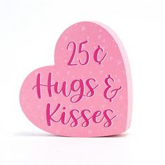 a pink heart shaped box with the words 25 hugs and kisses written on it's side