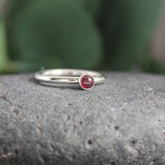 Garnet symbolizes love and is the gemstone to give for the 2nd anniversary. It is also the birthstone for January. This simple sterling silver stacking ring is a great gift, or an addition to a collection of stacking rings. Here are the details: This ring is made with a 4mm or 5-6mm bezel set garnet cabochon set on a sturdy sterling silver band handmade in your size. It can be worn with other stackable rings, or by itself.Please select your ring size. Sizes are US based. Classic Everyday Stackable Birthstone Rings, Stackable Gemstone Rings For May Birthstone, Everyday Stackable Gemstone Rings For May Birthstone, Sterling Silver Stackable Rings, May Birthstone Gift, Sterling Silver Stackable Rings With Bezel Setting As Gift, Classic Everyday Sterling Silver Birthstone Ring, Silver Stackable Rings With Round Stones For Gift, Classic Midi Rings With Birthstone, Minimalist Stackable Birthstone Rings For Promise