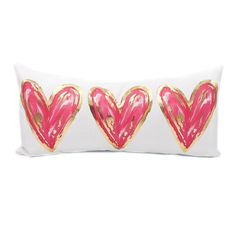 three pink and gold hearts on a white pillow with golden foil paint splatters