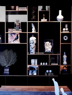 an image of a living room setting with vases and bookshelves on the wall