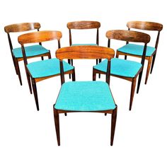 six wooden chairs with blue upholstered seats on each side and one in the middle