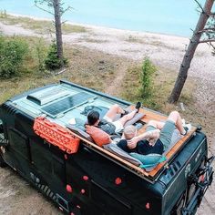 two people laying on the back of a truck with an open bed in front of them