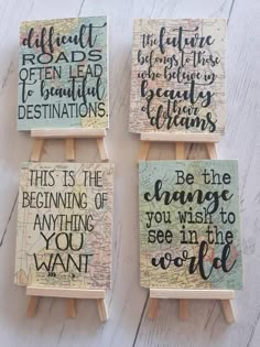 three small wooden eases with hand painted signs on them, one saying be the change you wish to see in the world