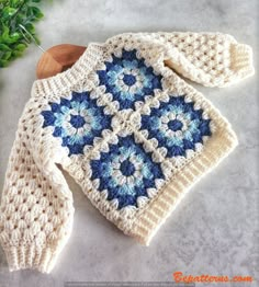 a blue and white crocheted dishcloth sitting on top of a wooden spoon