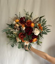 a bouquet of flowers is being held by someone's hand