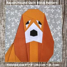 an orange and white dog made out of paper on top of a piece of wood