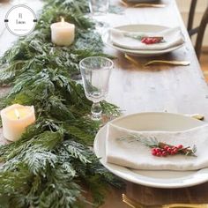 the table is set with candles and evergreen garland