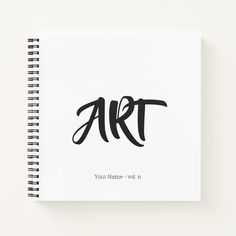 a spiral notebook with the word art written in black ink