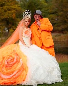 a man in an orange suit and woman in a white dress posing for a photo