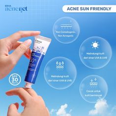 the hand is holding up a tube of sunscreen on a blue sky with white clouds