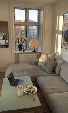 a living room filled with furniture and a laptop computer on top of a coffee table