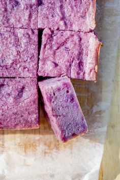 some kind of purple cake sitting on top of a wooden cutting board