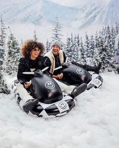 two people sitting on an inflatable snow tube