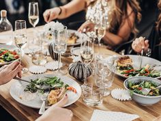 people sitting at a table with food and wine glasses