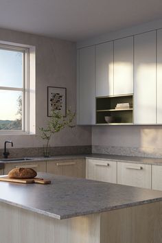 a kitchen with white cabinets and gray counter tops is pictured in this image, there is a bowl on the island