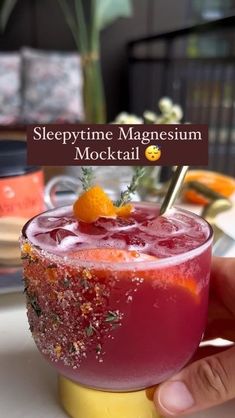 a hand holding a drink with an orange garnish on the rim and text reading sleepytime magnesium cocktail