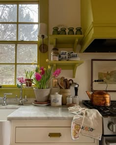 a kitchen with green painted walls and white counter tops, open shelving above the sink