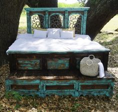 a bed made out of old drawers under a tree