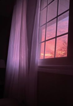 the sun is setting through an open window with white curtains and trees in the background