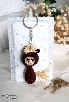 a crocheted keychain with a bear hanging from it's side