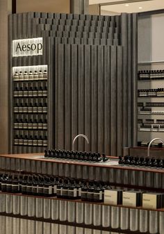 an assortment of wine bottles on display in a room with metal partitions and walls