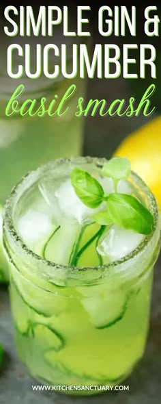 a close up of a drink in a glass with ice and green leaves on it