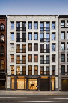 an apartment building with many windows on the front and side of it's facade