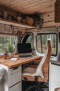 a laptop computer sitting on top of a wooden desk in the back of a van