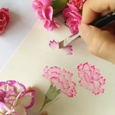 someone is cutting flowers with scissors on a piece of paper that has been cut into smaller pieces