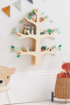 a wooden tree with animals in it next to a chair and wall hanging on the wall