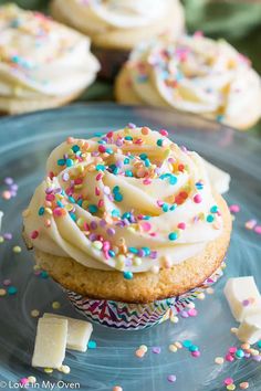 cupcakes with white frosting and sprinkles on a blue plate