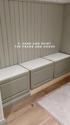 a white bench sitting in the middle of a room with gray walls and drawers on each side