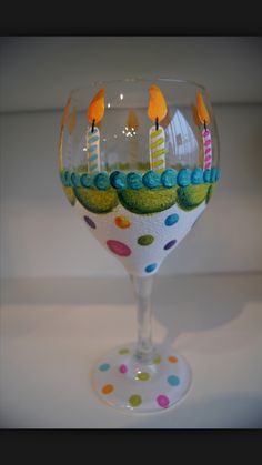 a wine glass with candles in it on a white tablecloth and polka dot dots