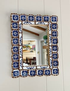 a blue and white mirror hanging on the wall