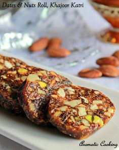 two pieces of food on a plate with almonds and other foods in the background