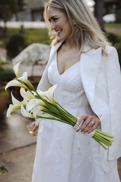 a woman in a white dress holding flowers