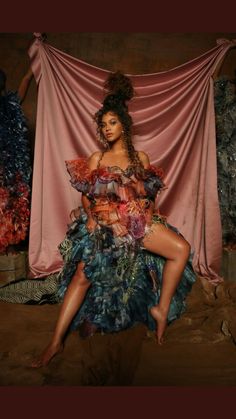 a woman sitting on top of a bed in a dress