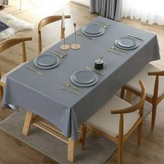 the table is set with plates and silverware on it, along with two chairs