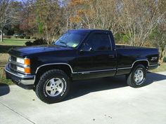 a black pickup truck parked in a driveway