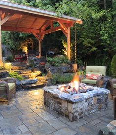 an outdoor fire pit surrounded by furniture and trees