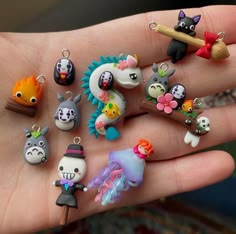 a hand holding a bunch of tiny animal charms