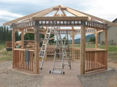 a wooden gazebo sitting on top of a dirt field