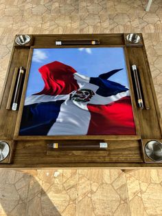 a wooden table topped with a glass and metal tray covered in a texas flag design