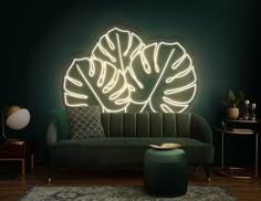 a living room with a green couch and large circular neon light sculpture on the wall