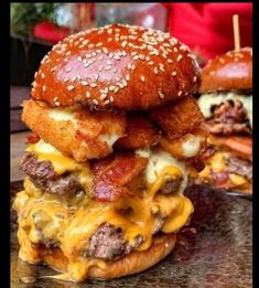 two cheeseburgers are stacked on top of each other, with meat and cheese