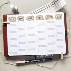 a planner with stickers on it next to a pen and some other items that include tape