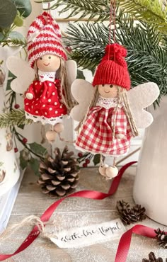 two angel ornaments hanging from a christmas tree