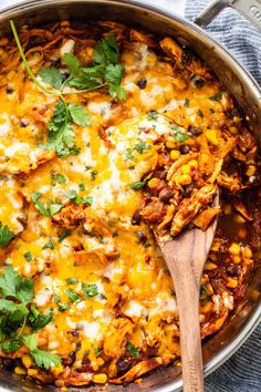 a skillet filled with mexican chicken and tortilla shells, garnished with cilantro