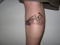 a man's leg with a tattoo of a dog playing the piano